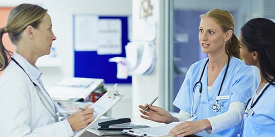 Three female clinicians discussing patient warming

