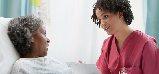 Clinicien parlant à un patient après une intervention chirurgicale
